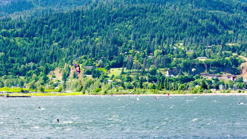 Lakeside Town with Windsurfers and Lush Green Hills