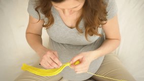 Top-down view of a pregnant woman knitting with yellow yarn. Her hands gently work with the needles, creating something soft and handmade for the baby. Calm, creative atmosphere - Powered by Shutterstock - Get 15% off with code: PIKWIZARD15
