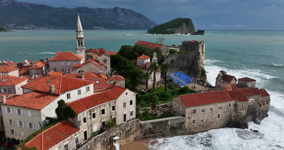Drone flying over famous Budva town with seascape at background in Montenegro.