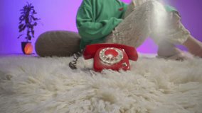 Extreme close-up of a woman’s hand gently pressing the handset of a red rotary phone, capturing the nostalgic charm of analog communication, textured by lace clothing and a cozy carpet setting - Powered by Shutterstock - Get 15% off with code: PIKWIZARD15
