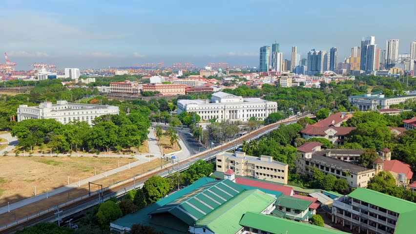 Scenic aerial view of city skyline with building skyscrapers, national museums, and Rizal Park in capital city of Manila Philippines