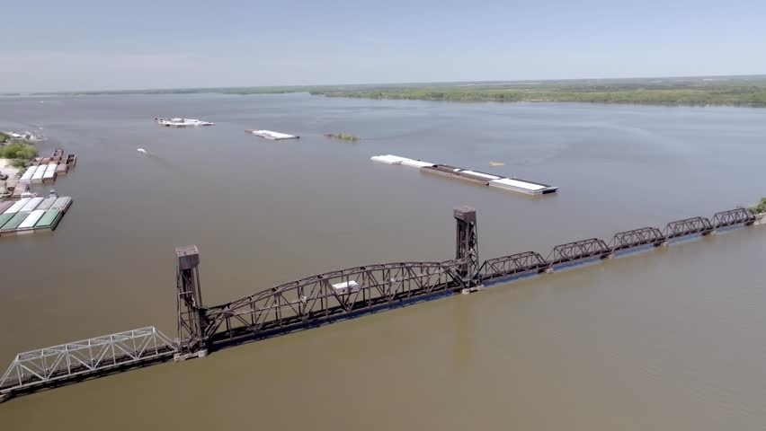 Railroad bridge in Decatur, Alabama over water with drone video moving in a circle.