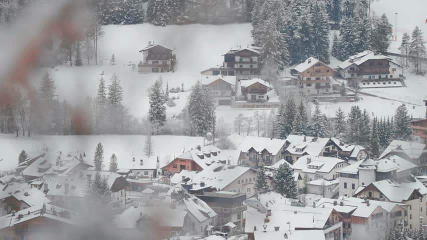 Snow-covered rooftops and chalet-style homes nestle together in this serene mountain village.