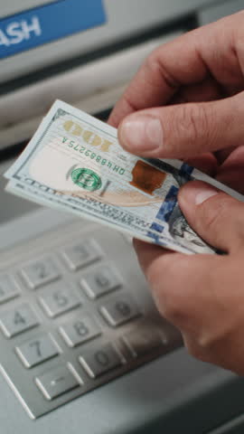 Unrecognizable Man, Businessman Counting US Dollar Bills in Hands After Withdrawing Cash Money Transaction from ATM Machine. Banking Services, Cash Withdrawal, Financial Operations. Vertical Shot.