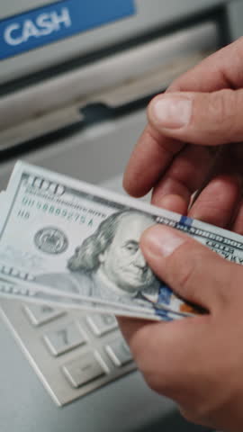 Close Up of Man, Businessman Counting US Dollar Bills in Hands After Withdrawing Cash Money Operation from ATM Machine. Banking Services, Cash Withdrawal Systems, Financial Transactions. Vertical Shot