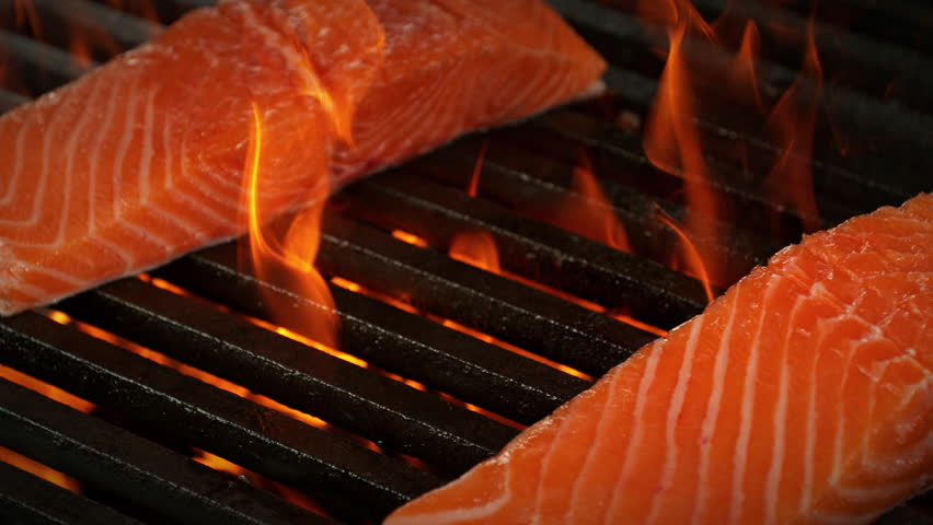 Super Slow Motion Shot of Salmon Filet Falling on Fired Up Grill at 1000fps.