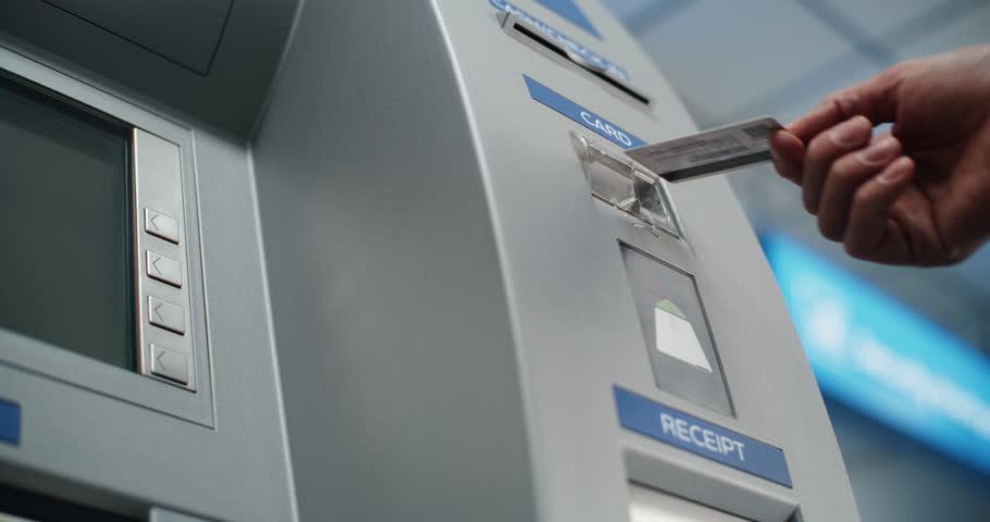 Cash Machine in Airport Terminal: Unrecognizable Person Inserting Plastic Credit Card Into Card Reader Slot for Cash Withdrawal Transaction. Automated Teller Machine, Banking Services. Close Up Shot.