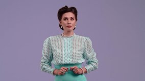 Young woman in vintage outfit, with glamorous hairstyle poses on purple studio background. Actress in retro style screams in terror and covers her face with her hands. Beauty and vintage style concept - Powered by Shutterstock - Get 15% off with code: PIKWIZARD15