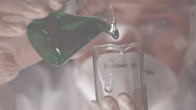 Woman wearing gloves pouring green solution into beaker in science lab showing red heart overlays. Laboratory, science, chemistry, innovation, research, healthcare, experimental - Powered by Shutterstock - Get 15% off with code: PIKWIZARD15