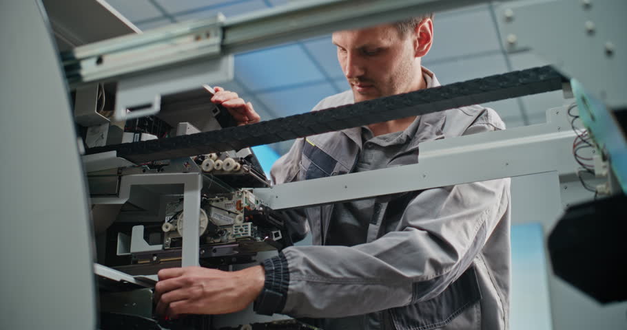 Technician Servicing ATM Machine in Modern Airport Terminal. Male Worker in Uniform Repairing Internal Components of Automated Teller Machine. Banking Services and Cash Withdrawal Systems. Close Up.