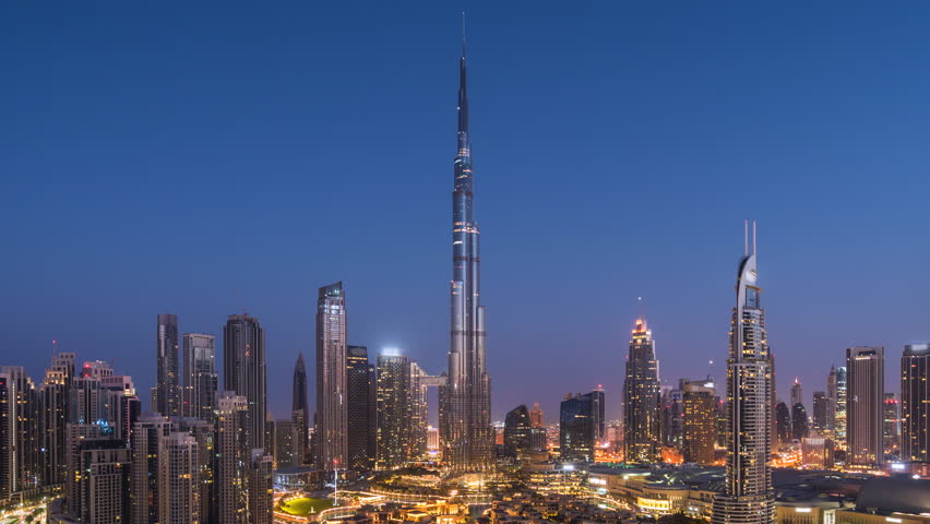 Timelapse of view of sunrise over the Burj Khalifa and other towers in Downtown Dubai, United Arab Emirates (UAE), modern cities and skylines, business and finance concept, zooming out. 