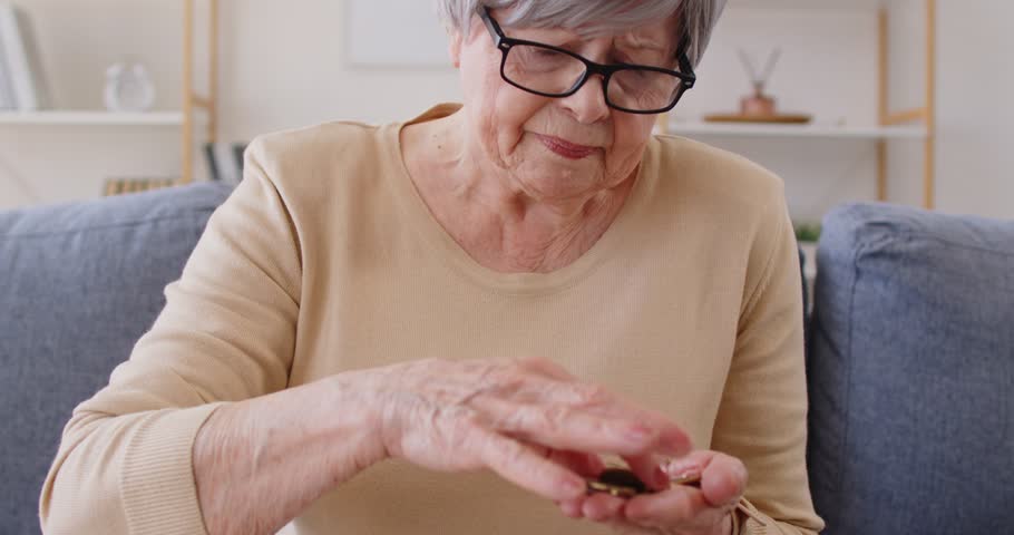 Mature woman being poor, counting coins, has to survive on miserable pension, has poor lifestyle. Worried senior lady being short of money on pension. Poverty, retirement problems concept