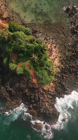 Aerial top down view Mirissa Beach and Parrot Rock, showcasing pristine turquoise waters, golden sandy shores, rocky coastal formations, southern Sri Lanka. Vibrant tropical landscape indian ocean