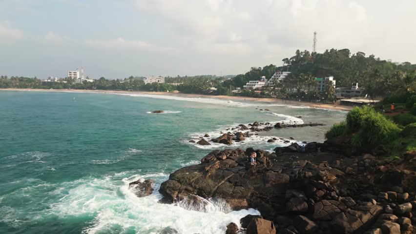 Breathtaking aerial view Mirissa Beach and Parrot Rock, showcasing pristine turquoise waters, golden sandy shores, rocky coastal formations, southern Sri Lanka. Vibrant tropical landscape indian ocean
