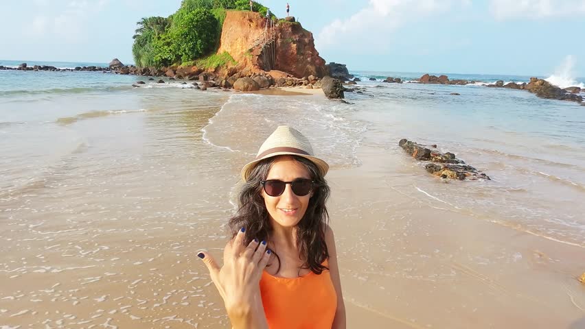 Excited Tourist smiley Woman Running Joyfully in Scenic Sri Lanka sunny beach.Parrot island popular landmark attraction. Mirissa coastline. Sri lanka travel sightseeing concept.