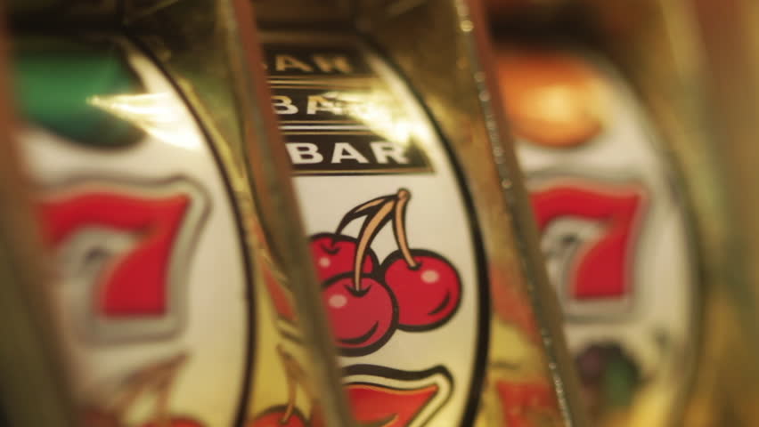 macro of a old toy slot machine spinning to 777 win 
