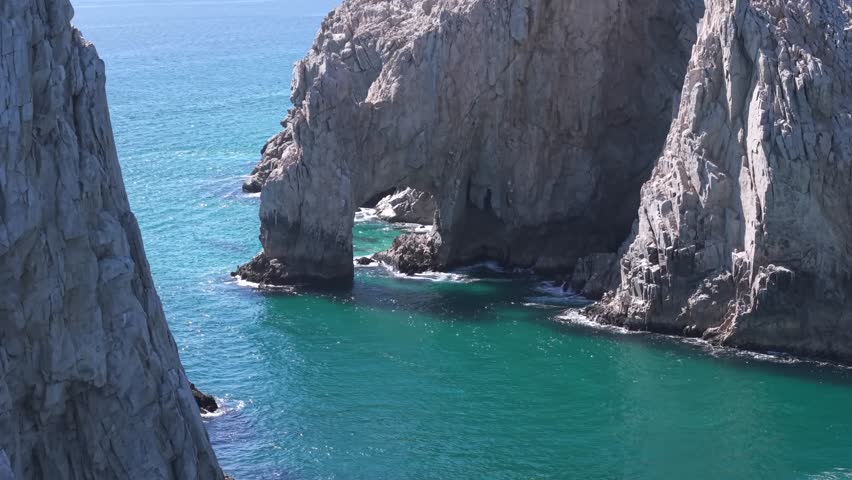 The famous arch of Cabo San Lucas, Mexico - a distinctive granitic rock formed by erosion - rising aerial view