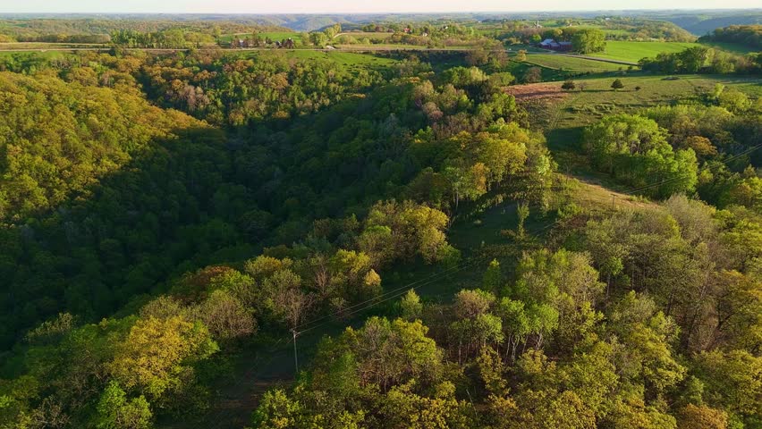 Aerial video from Apple Blossom Overlook Park showing rolling green hills and farmland at sunset with golden light over the rural Wisconsin landscape.