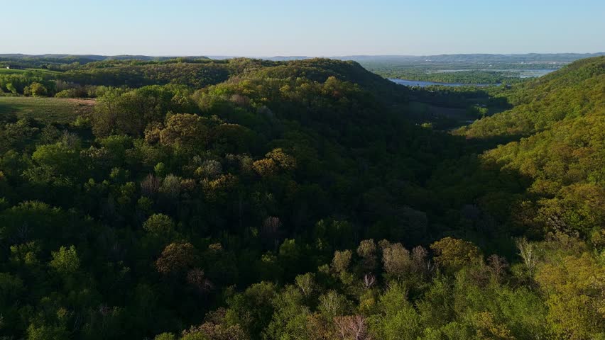 Aerial video from Apple Blossom Overlook Park showing rolling green hills and farmland at sunset with golden light over the rural Wisconsin landscape.