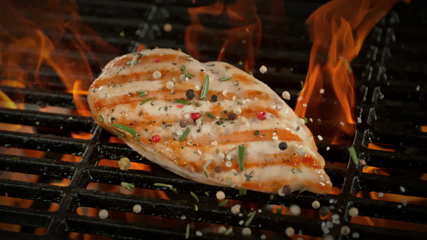 Super Slow Motion of Seasoning Falling on Chicken Breast on Grill with Camera Motion at 1000fps.