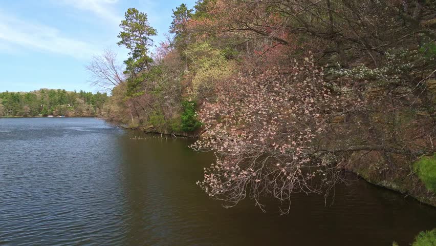 Drone video flying over Mirror Lake State Park in Wisconsin capturing Echo Rock’s scenic sandstone cliffs and calm lake reflection from the water.