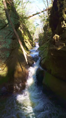 Drone video flying over Pewits Nest in Wisconsin showcasing scenic glacier-carved gorge, cascading waterfall, and forest stream.