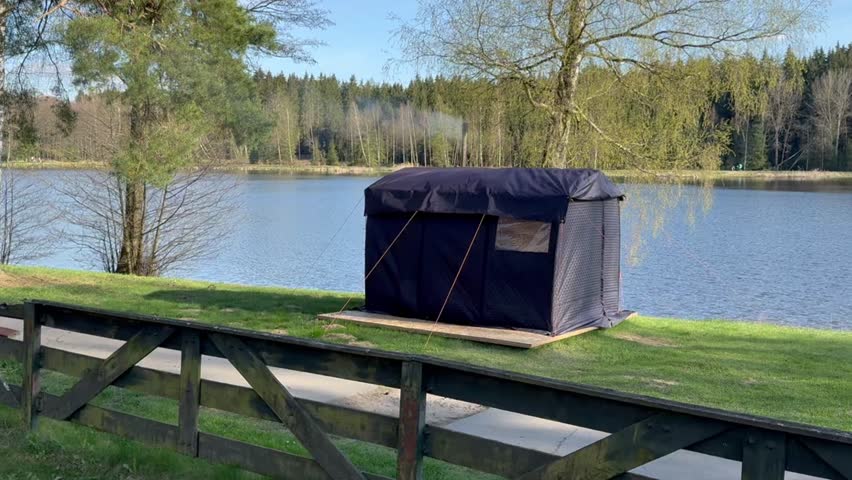 Tent by the lake among morning trees