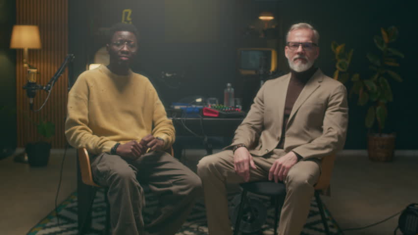 Zoom in portrait shot of African American male host and mature Caucasian businessman posing for camera in podcast studio