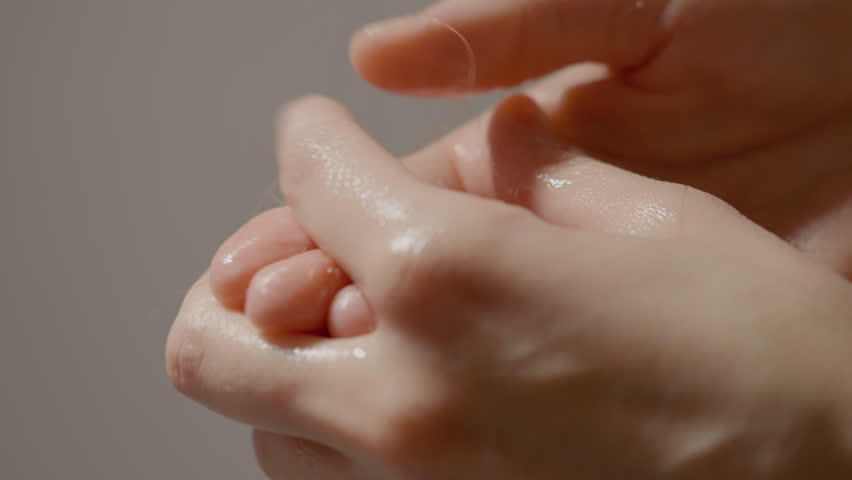Hands are shown in a close-up as they wash hair in the shower. Hair strands fall into the palms, illustrating the struggle with hair loss and weak hair during washing.