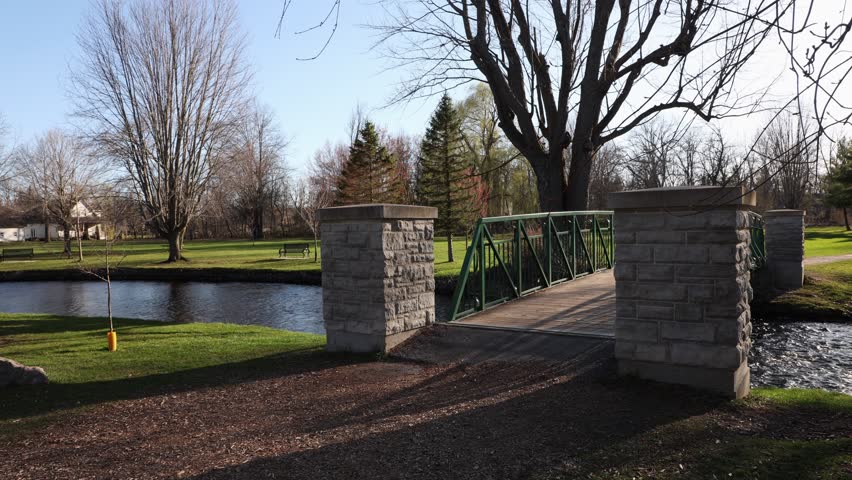 Park view in spring with a bridge over stream. Stewart Park In Perth, Ontario, Canada.