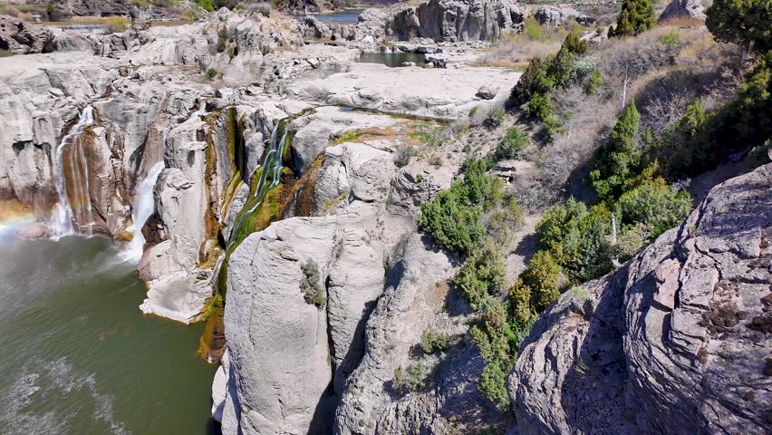 Panning view of Shoshone Falls with a rainbow during spring in the Snake River Canyon near Twin Falls, Idaho.