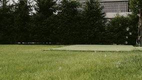 Fresh green grass with soap bubbles, beautiful lawn with sun rays in early morning, country house, cottage and forest blurred in background. High quality FullHD footage - Powered by Shutterstock - Get 15% off with code: PIKWIZARD15