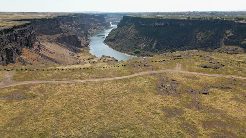 Flying over the Snake River Canyon, revealing Pillar Falls and Shoshone Falls in the distance.