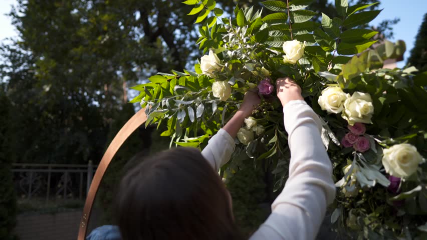 Staff event agency at work. Florists mount, decorate flowers arch for wedding ceremony. Work creating wed decor by professional. Floristics. Decorator working with flowers composition for wedding arch