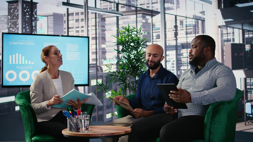 Corporate leadership team in a business meeting use data driven analysis and strategic thinking to identify insights and guide executive decisions across a global company. Camera A.