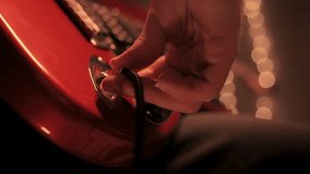 A man is turning the volume knob on an electric guitar and start playing. Close up view - Powered by Shutterstock - Get 15% off with code: PIKWIZARD15
