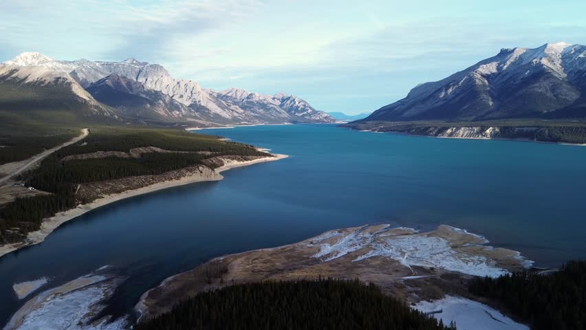 Blue glacial lake and cliffs in Jasper, Alberta, viewed from above by drone