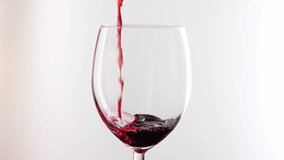 Red wine slowly pouring in glass over white background. High quality 4k footage - Powered by Shutterstock - Get 15% off with code: PIKWIZARD15