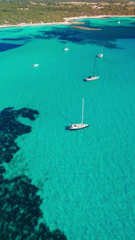Aerial view of the stunning Mediterranean Sea coast in Mallorca, Balearic Islands, Spain. Peacefully moored sailboats in the incredible turquoise waters of Mallorca island.