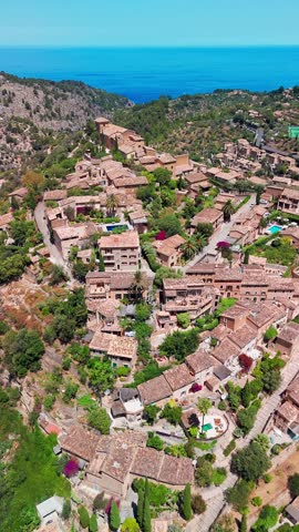 Deia town, Mallorca, Balearic Islands, Spain. Aerial view of picturesque mountain village with stone houses and rustic rooftops, Deia, Majorca, Spain.