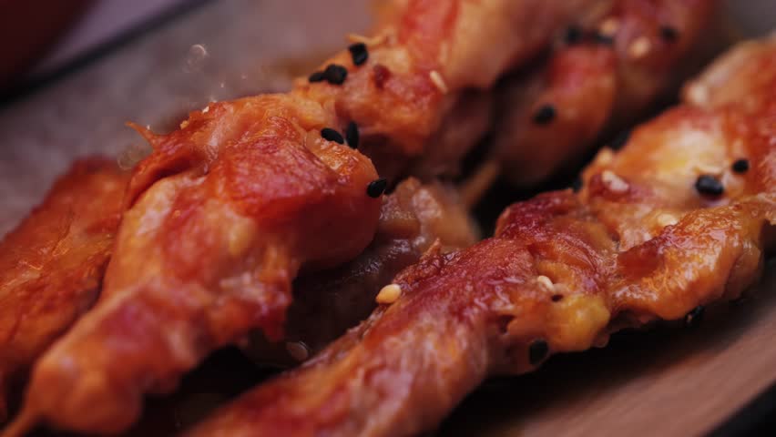 Asian dish chicken on a skewer fried in teriyaki sauce with seed sesame. High quality 4k footage