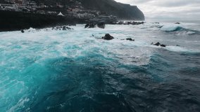 FPV drone flying along Porto Moniz coast, Madeira, over massive ocean waves crashing against cliffs. Aerial 4K footage for travel, adventure, nature and cinematic projects. Natural Swimming Pools - Powered by Shutterstock - Get 15% off with code: PIKWIZARD15