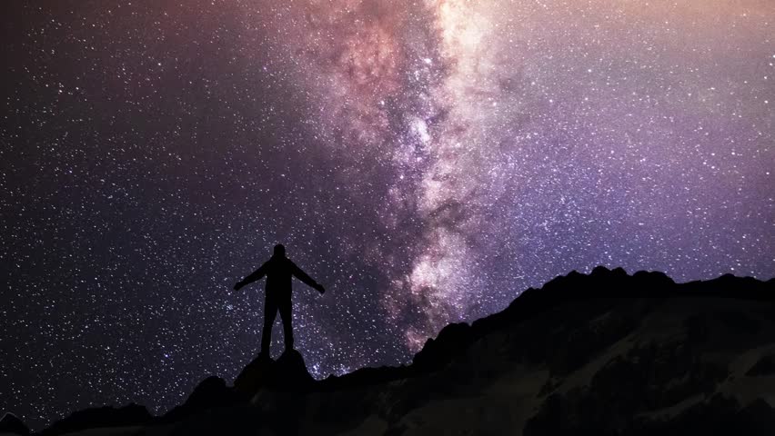 Hiker silhouette stands  on the hill on the  Milky Way galaxy and  mountains background. Night tight landscape starry sky.