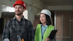 Two Caucasian Japanese builders contractors man woman industry workers hardhat speaking examining blueprint paper building business construction inspector clapping hands celebrating success inspection - Powered by Shutterstock - Get 15% off with code: PIKWIZARD15