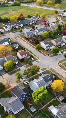 Aerial View of Suburban Neighborhood in Fall. Vibrant aerial view of a suburban neighborhood with colorful autumn trees, neatly arranged houses, and winding streets.