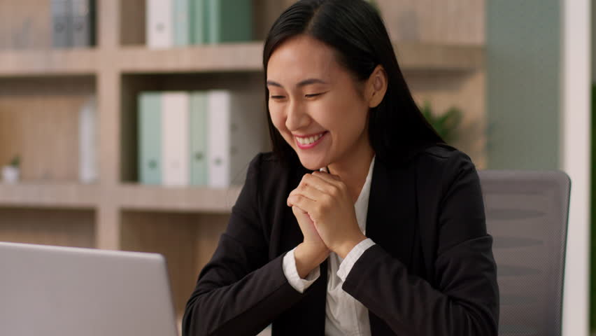 Overjoyed happy excited Chinese Korean female winner girl businesswoman ethnic Japanese business woman working laptop desktop computer online victory win money bet gambling amazement awe shock indoor