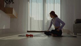 A woman sitting on a fitness mat engages her cat by using a toy on a rope in a living room. They share joyful, energetic playtime while promoting a healthy lifestyle. - Powered by Shutterstock - Get 15% off with code: PIKWIZARD15