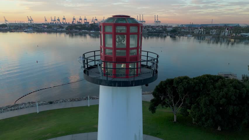 Aerial view of Lions Lighthouse at sunrise, revealing calm waters and distant ships in Long Beach, California.