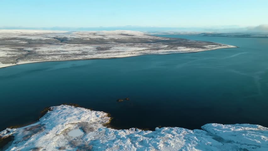 Aerial view of Motovsky Bay showing snow-covered land formations and icy sea, highlighting the beauty of Russia’s Arctic coast.