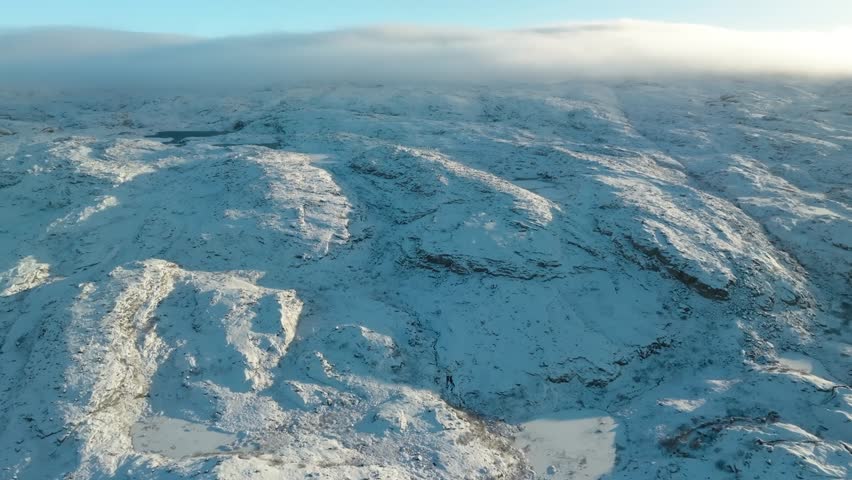 Drone captures Alaska’s icy expanse with white mountain ridges and glacier fields, a breathtaking view of North America’s last frontier.